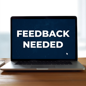 An open laptop with the words "Feedback Needed" on the screen